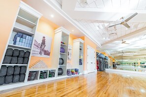 A gym with wooden floors, ceiling fans, and various exercise equipment. - Luxury Waterfront Living! Naples Resort Condo (Naples)