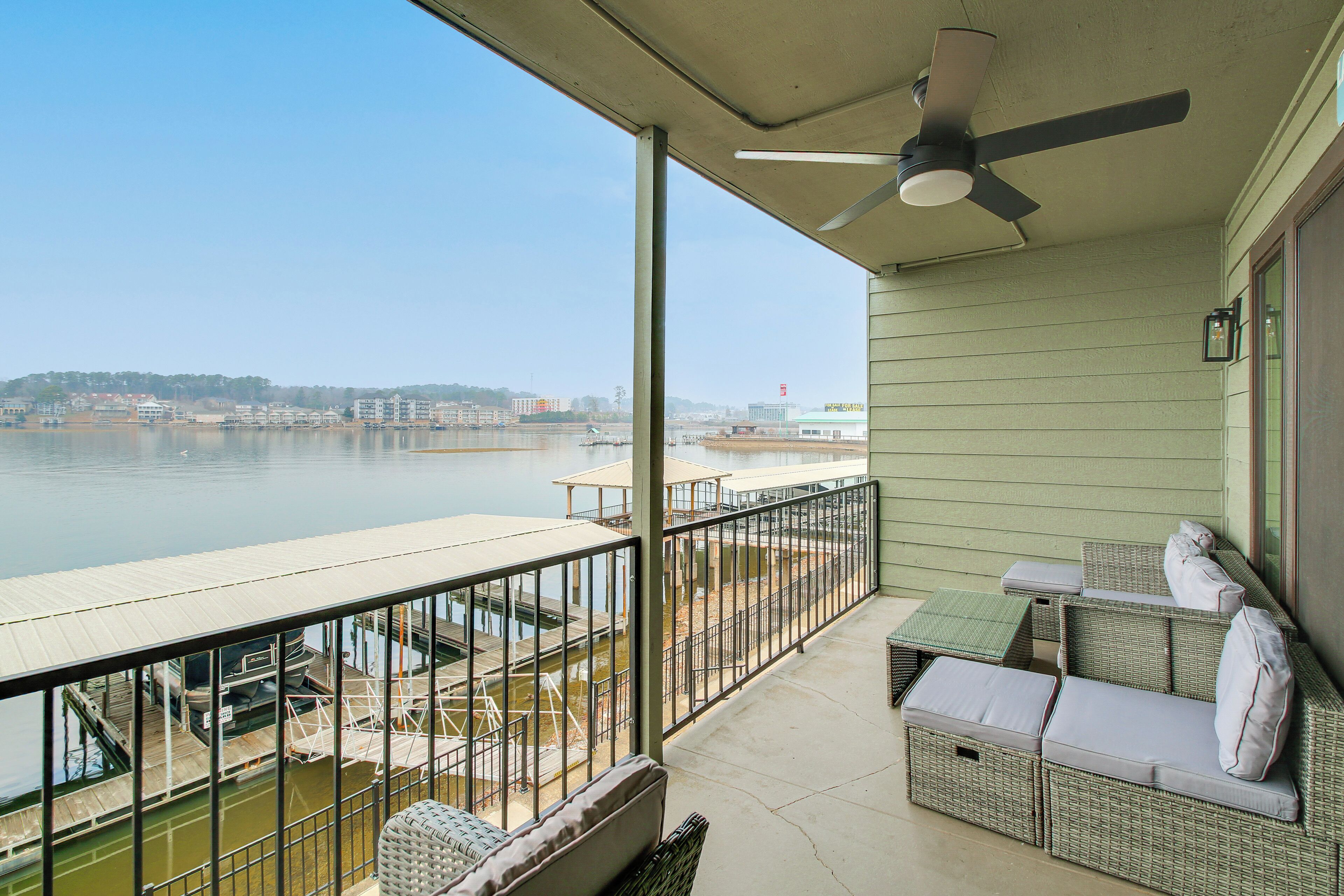 Un balcon avec vue sur une étendue d’eau, un ventilateur de plafond et du mobilier d’extérieur.