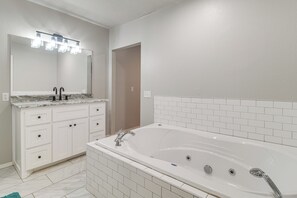 A bathroom with a white bathtub, a double sink vanity, and a large mirror with overhead lighting. - Group Getaway Near Eufaula Lake & Boat Ramp! (Eufaula)