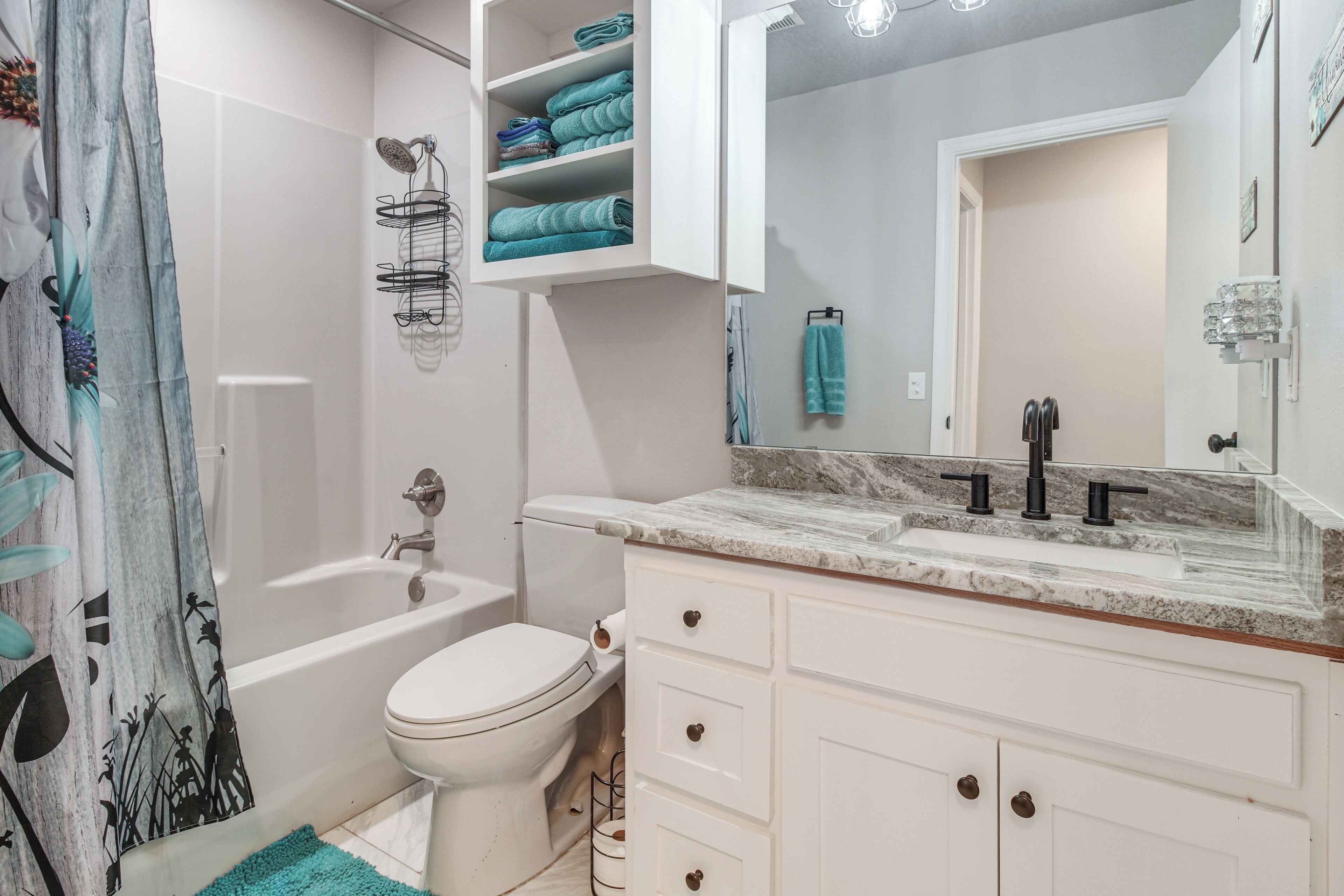 Une salle de bain avec une baignoire, des toilettes et un meuble-lavabo avec un miroir.