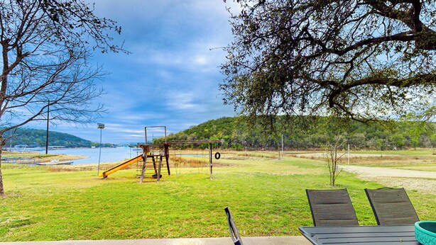Un parc équipé d’une aire de jeux, d’une table de pique-nique et offrant une vue sur un lac.