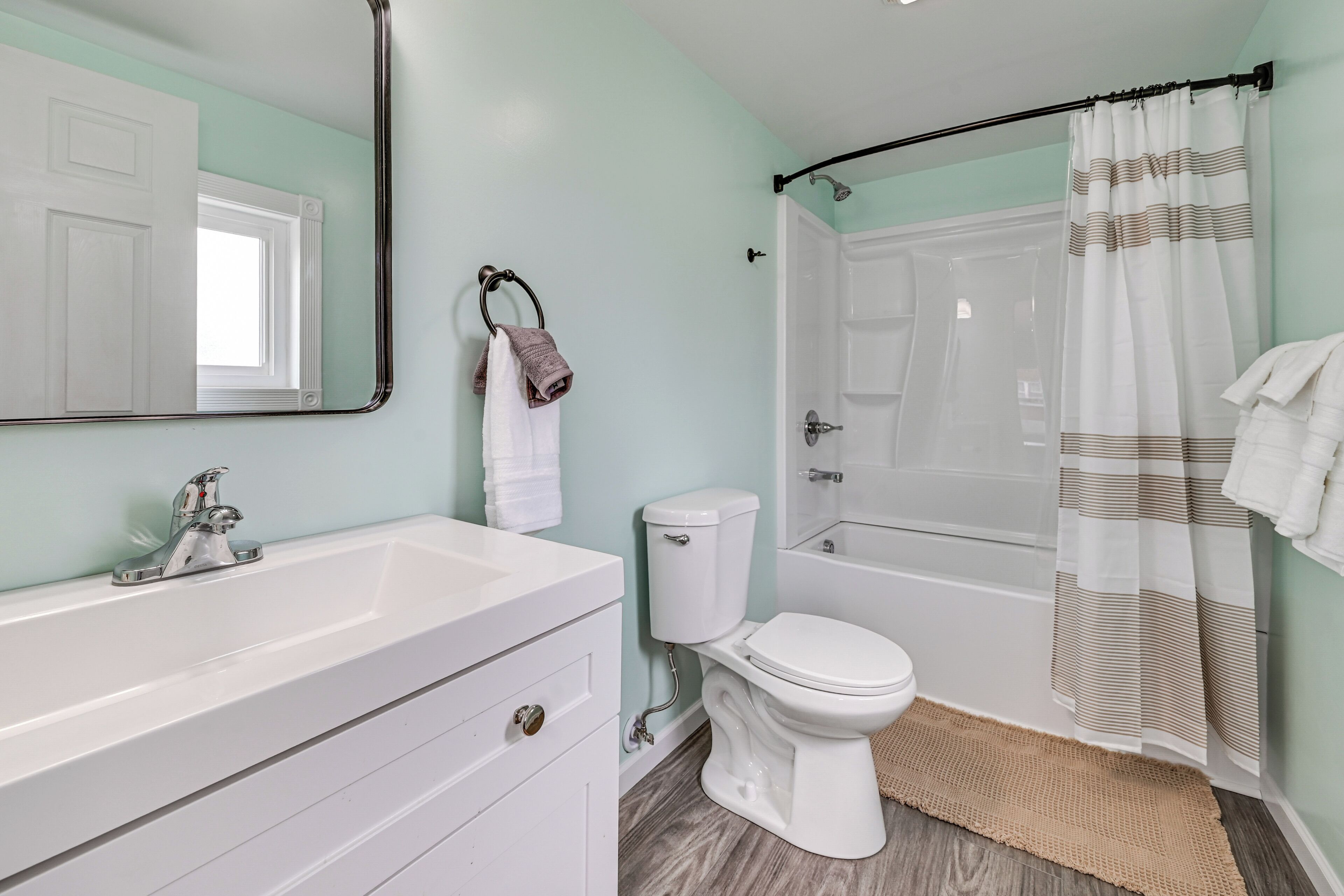 Une salle de bain avec un lavabo, des toilettes et une baignoire, le tout de couleur blanche.