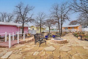 A patio area with stone flooring, a fire pit, and outdoor seating. - Peace & Relaxation at Texas Countryside Tiny Home (Bowie)