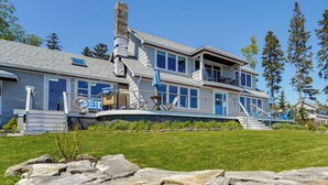 A two-story house with a balcony, a chimney, and a stone wall in the foreground. - < 1 Mi to Port Clyde Village: Modern Retreat (Tenants Harbor)