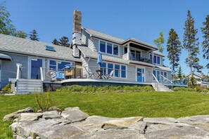 A two-story house with a balcony, a chimney, and a stone wall in the foreground. - < 1 Mi to Port Clyde Village: Modern Retreat (Tenants Harbor)