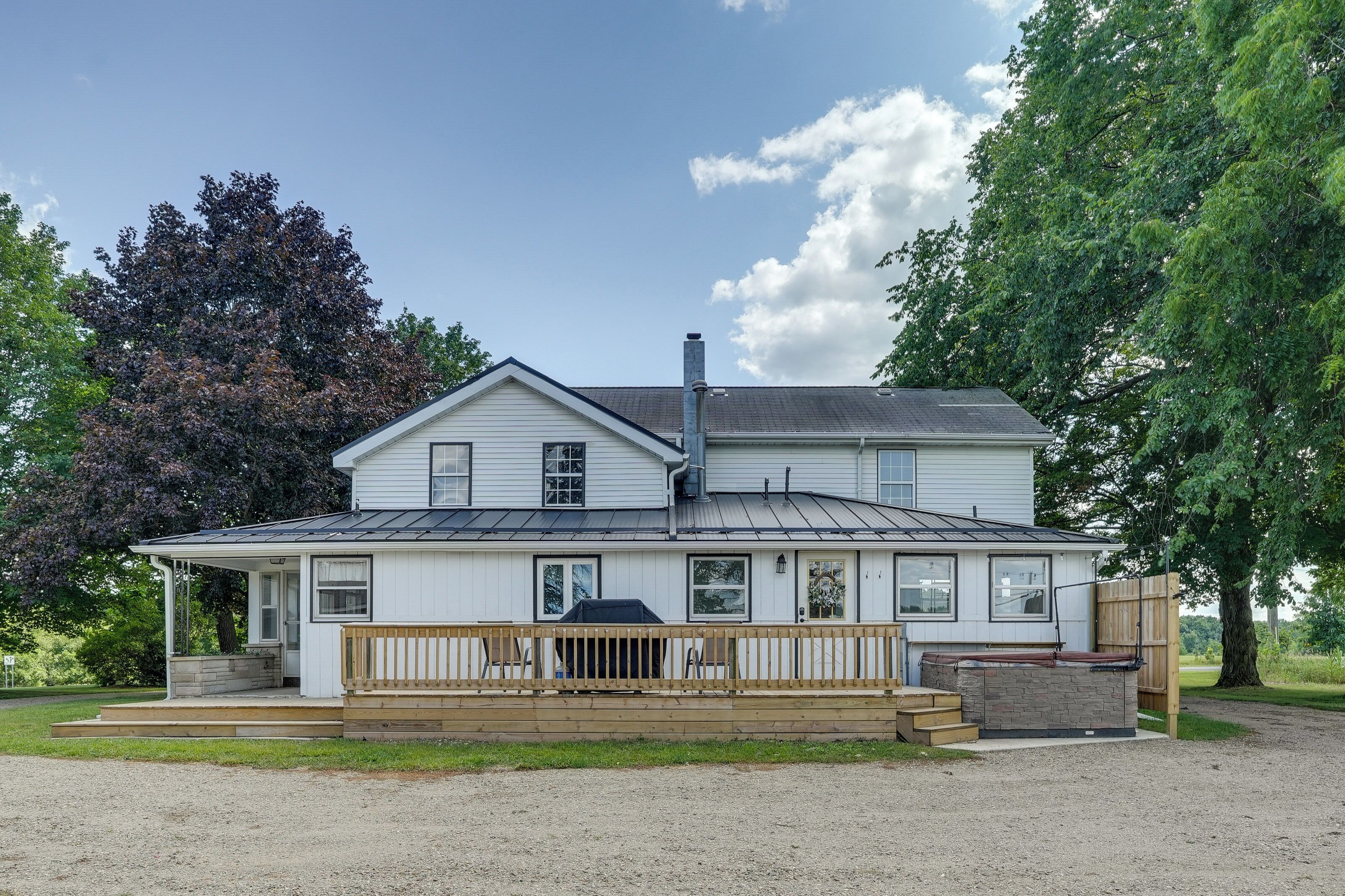 A two-story house with a covered porch and a chimney.