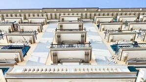 Een statig architectonisch gevelontwerp met symmetrische balkons en versierde details.