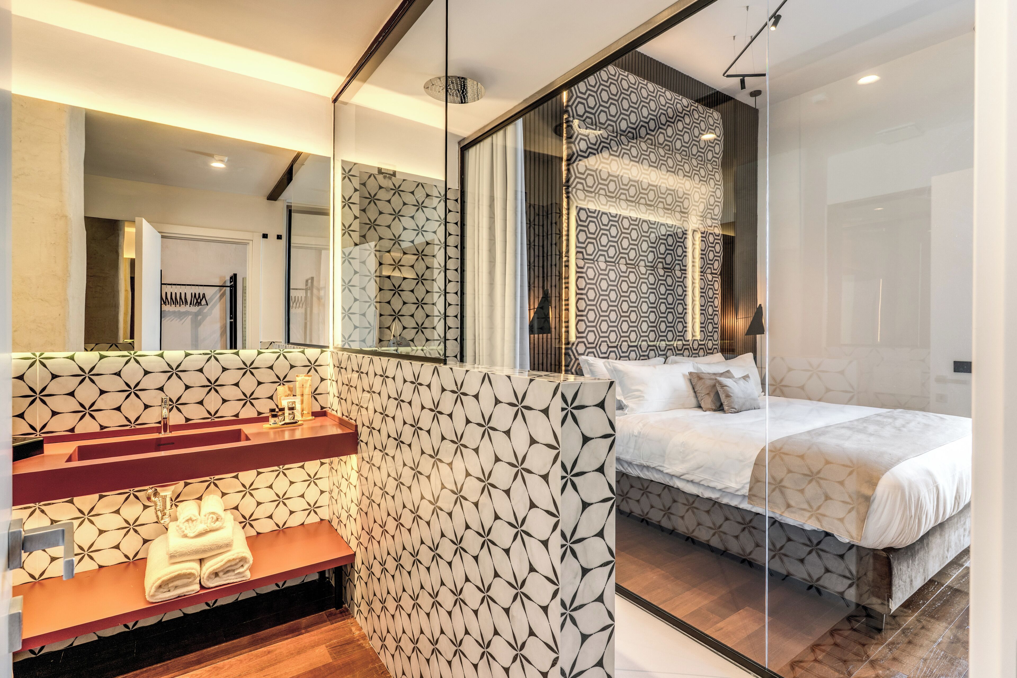 A modern bathroom with a geometric tile backsplash, a vanity with a mirror, and a shower area.