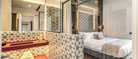 A modern bathroom with a geometric tile backsplash, a vanity with a mirror, and a shower area.