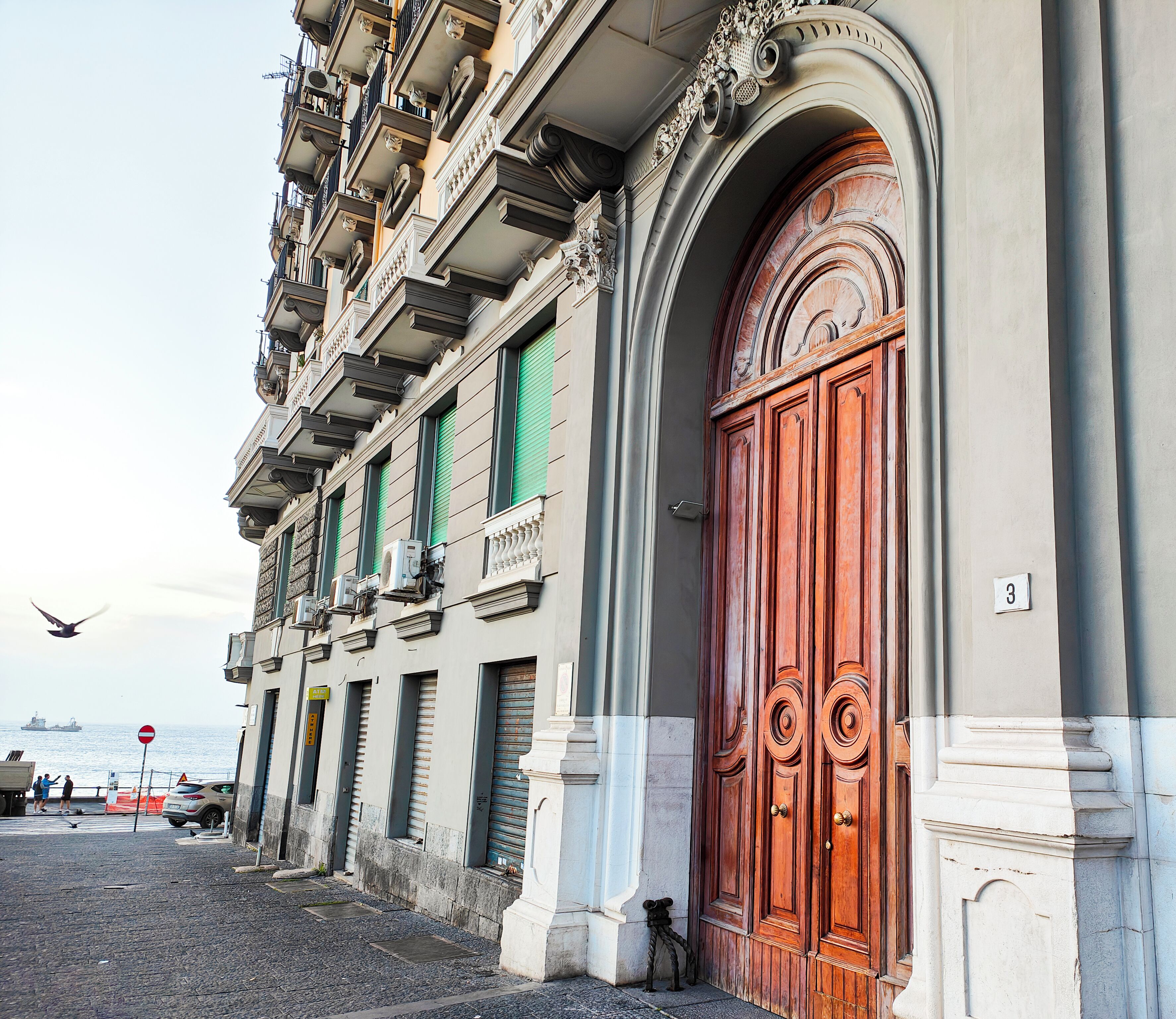 A building with ornate architectural details, including a large wooden door and multiple balconies.