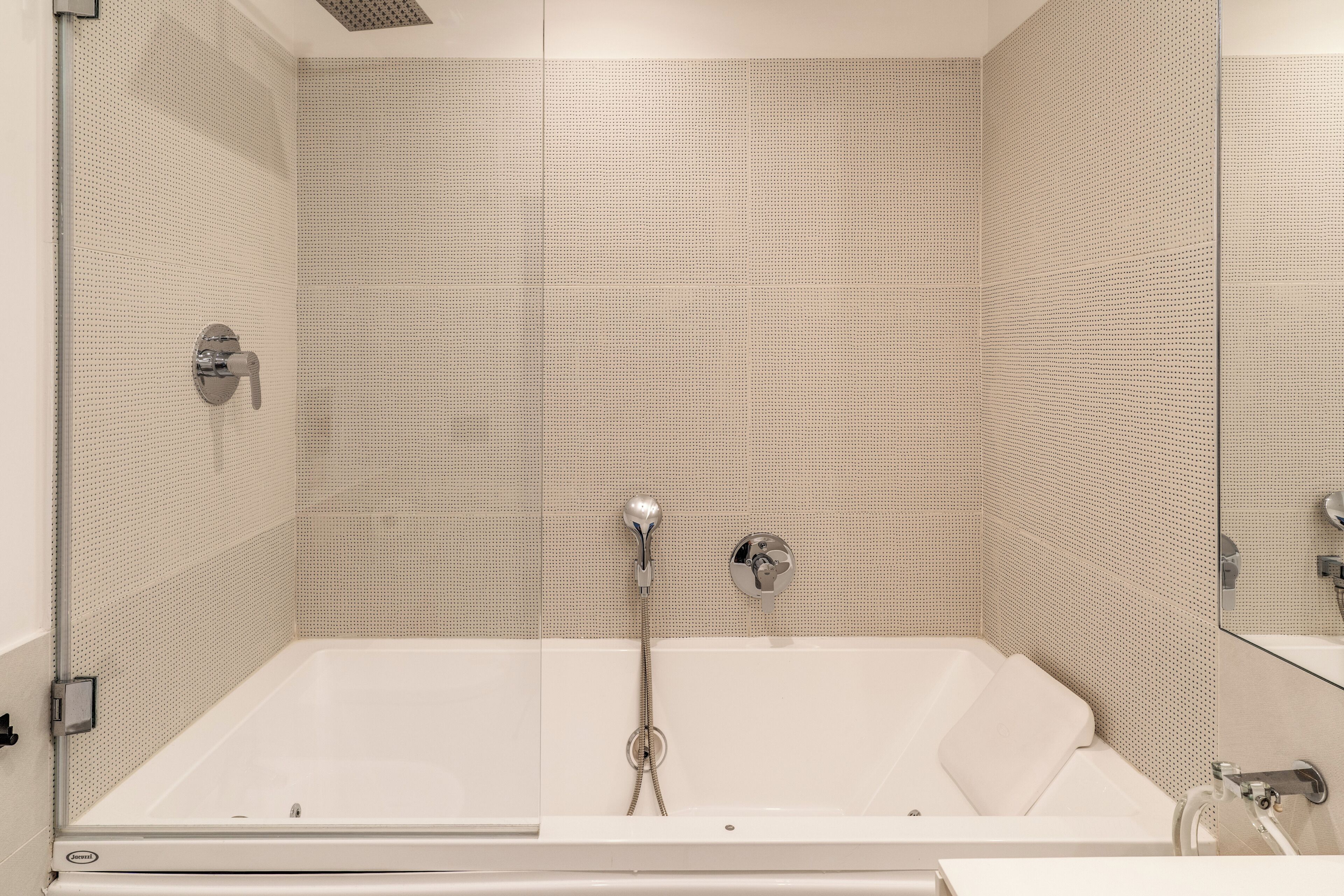 Une salle de bain moderne avec une baignoire sur pieds, une pomme de douche et un robinet mural.