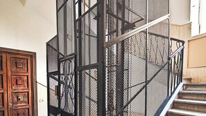 Een trap met een metalen leuning en marmeren treden.