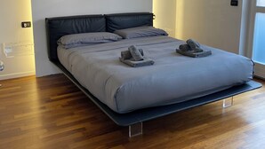 Una camera da letto moderna con un letto, pavimento in legno e una finestra.