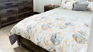 A bedroom with a bed, wooden dresser, nightstand, and a mirror. - Charming 3BR Near Ponce Attractions (Ponce)