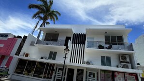 A multi-story building with a modern design, featuring balconies and large windows. - Charming 3BR Near Ponce Attractions (Ponce)