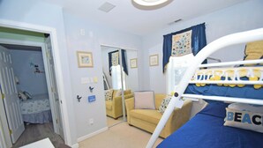 A child's bedroom with bunk beds, a desk, a chair, a yellow sofa, and a mirror. - Montego Bay-Colonial Drive 13339-Bayside 135th Street (pets allowed) (Ocean City)