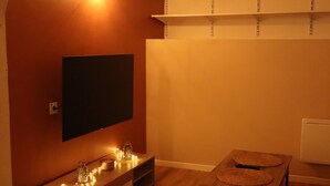 Un bagno moderno con un mobile bagno in legno, uno specchio e un televisore a parete.