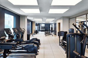 A gym with treadmills, elliptical machines, and weightlifting equipment. - Near Fenway | Gym. Restaurant + Full Kitchen (Boston)