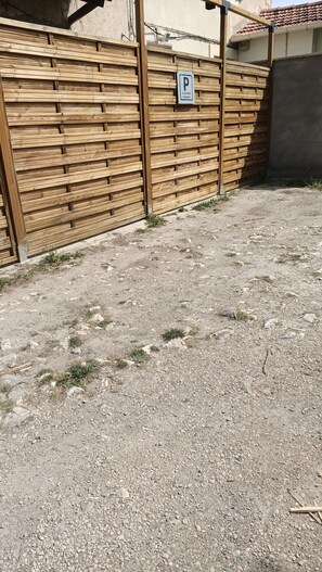 A gravel driveway leading to a wooden fence with a parking sign. - Holiday Home 'La halte provençale - Cocooning' with Private Terrace, Wi-Fi & Air Conditioning (Châteaurenard)