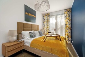 Une chambre à coucher moderne avec un lit en bois, une table de chevet, une lampe et un tableau au mur.