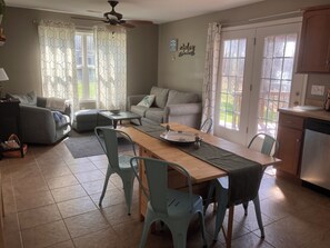 A dining area with a wooden table, chairs, and a kitchen in the background.
