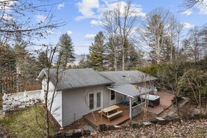 Ein Haus mit Terrasse, Whirlpool und einer Holzdeck.