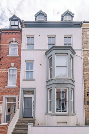 A two-story building with a bay window and a door. - The Snug by the Sea - Central Whitby, Beach Front (West Cliff)