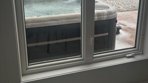 Vista desde la ventana de un jacuzzi sobre una superficie helada bajo un cielo nublado.
