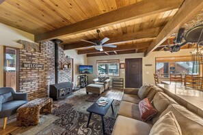 A cozy living room with a fireplace, wooden ceiling, and a 'Welcome' sign on the wall. - Sierra Pines Cabin BBQ, Fireplace, Updated Kitchen (South Lake Tahoe)