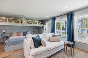 A bedroom with a bunk bed, a sofa, a small table, and a window with curtains. - Making Memories, Beach, Golf Cart, Pool & Dock (Santa Rosa Beach)