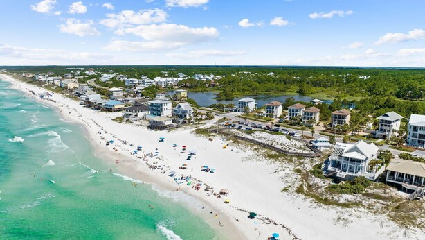 A coastal resort with beachfront villas, a sandy beach, and a view of the ocean.