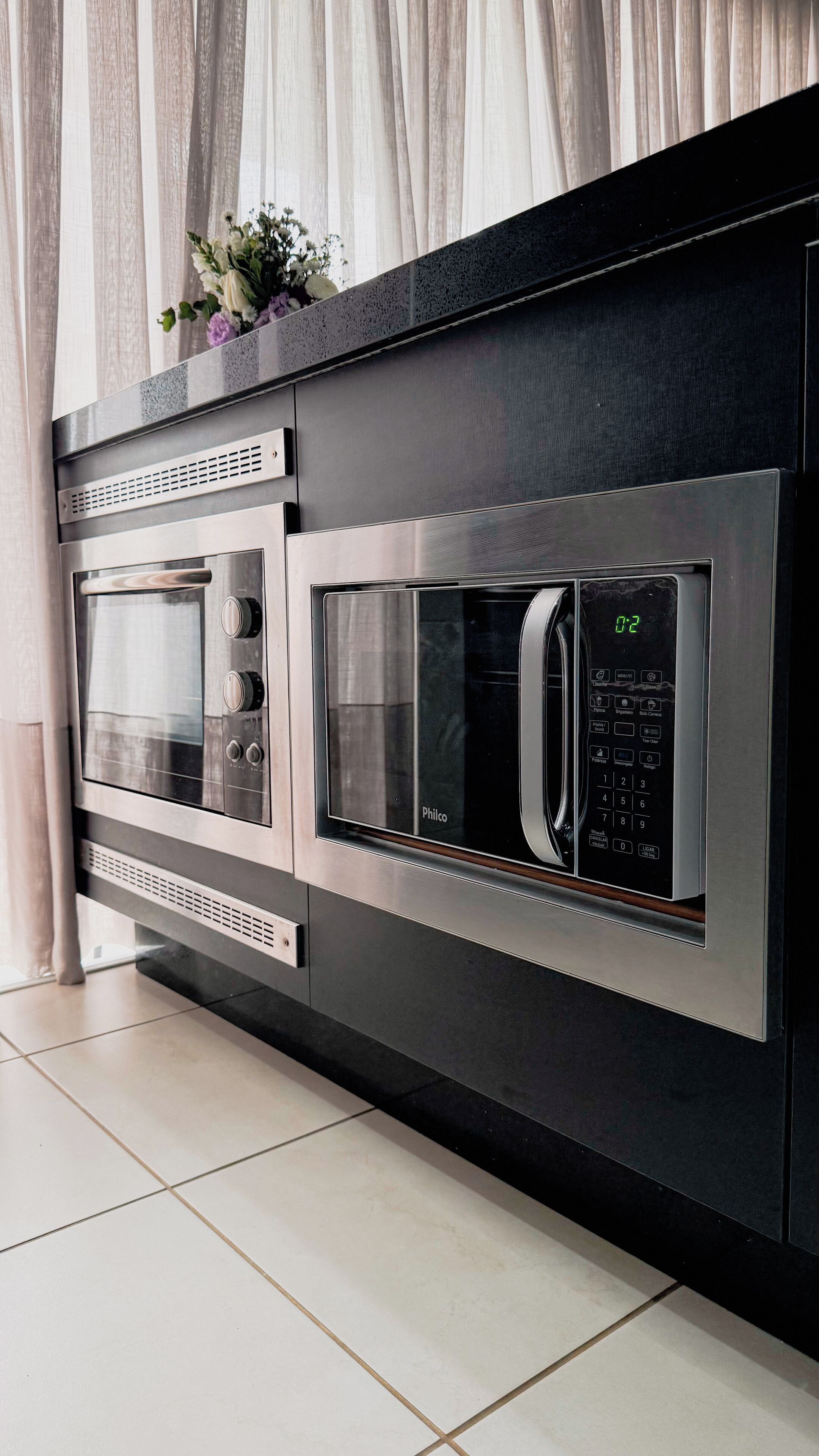 Una cocina con dos hornos empotrados y un microondas.