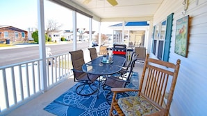 A covered patio with a table and chairs, a ceiling fan, and a view of the street. - Montego Bay-colonial Drive 13339 3 Bedroom Home (Ocean City)