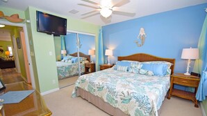 A bedroom with a large bed, two bedside tables, a ceiling fan, and a TV mounted on the wall. - Montego Bay-colonial Drive 13339 3 Bedroom Home (Ocean City)