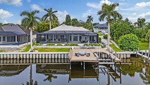 A modern house with a swimming pool, a dock, and a well-maintained garden. - Peaceful on canal 3-bedroom house with pool and dock in Marco Island (Marco Island)