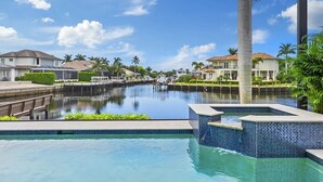 A swimming pool with a view of a marina and houses in the background. - Peaceful on canal 3-bedroom house with pool and dock in Marco Island (Marco Island)