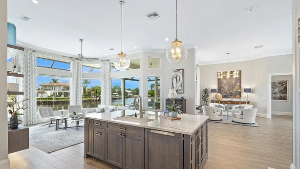 A spacious kitchen with a large island, modern pendant lights, and a view of the outdoors. - Peaceful on canal 3-bedroom house with pool and dock in Marco Island (Marco Island)