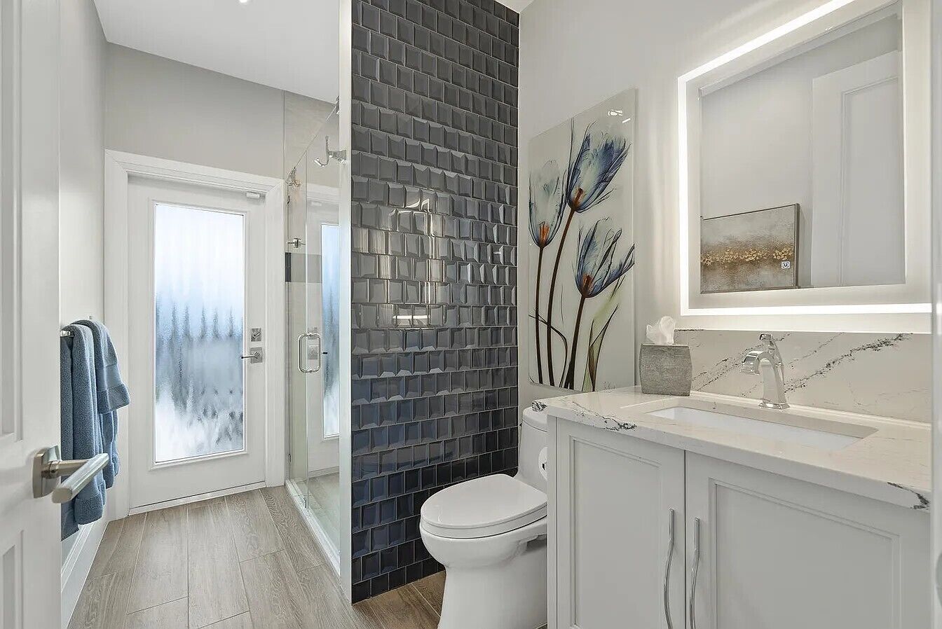 A modern bathroom with a glass shower enclosure, a white toilet, and a marble countertop.