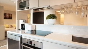 Una cocina moderna con electrodomésticos de acero inoxidable, horno empotrado y cafetera.