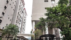 A high-rise building with a tiled facade and multiple balconies. - StayHome 1min da Praia | São Vicente SP | Família ou Casal (São Vicente)