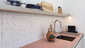 A kitchen with a speckled backsplash, a wooden cutting board, a vase, and a coffee machine. - Casa Vento -  Koksijde (Koksijde)