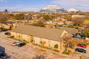 A building with a parking lot, a staircase, and a large dome-shaped structure in the background. - Entertainment District Escape • 2BR + Parking (Arlington)