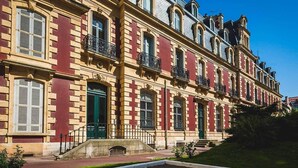 A row of red and beige buildings with multiple windows and balconies. - LOFT · KEYWEEK contemporary Loft style Apartment in Biarritz City center (Biarritz)