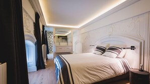 A modern hotel room with a large bed, a bedside table, a mirror, and a view of the bathroom. - LOFT · KEYWEEK contemporary Loft style Apartment in Biarritz City center (Biarritz)