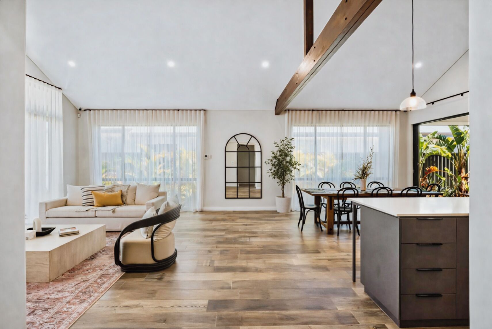 A spacious living area with a sofa, dining table, and kitchen area.