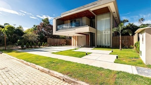 Una moderna casa a due piani con tetto piatto, ampie finestre e un balcone.