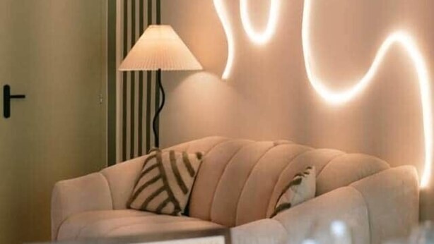Un salon moderne avec un canapé, une lampe et un climatiseur fixé au mur.