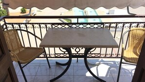A balcony with a table and two wicker chairs. - Argo apartments near Nafplio (Nea Kios)