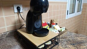 A coffee maker on a kitchen counter with a tray of coffee pods and a box of coffee creamer. - Vionta: Your cozy retreat with garden view near the beach (Aguiño)