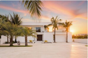 A modern two-story building with a flat roof and large windows, surrounded by palm trees and a well-maintained lawn. - Palm Villa Chiang Mai Award-Winning Luxury Villa with Private Pool (Tambon San Na Meng)